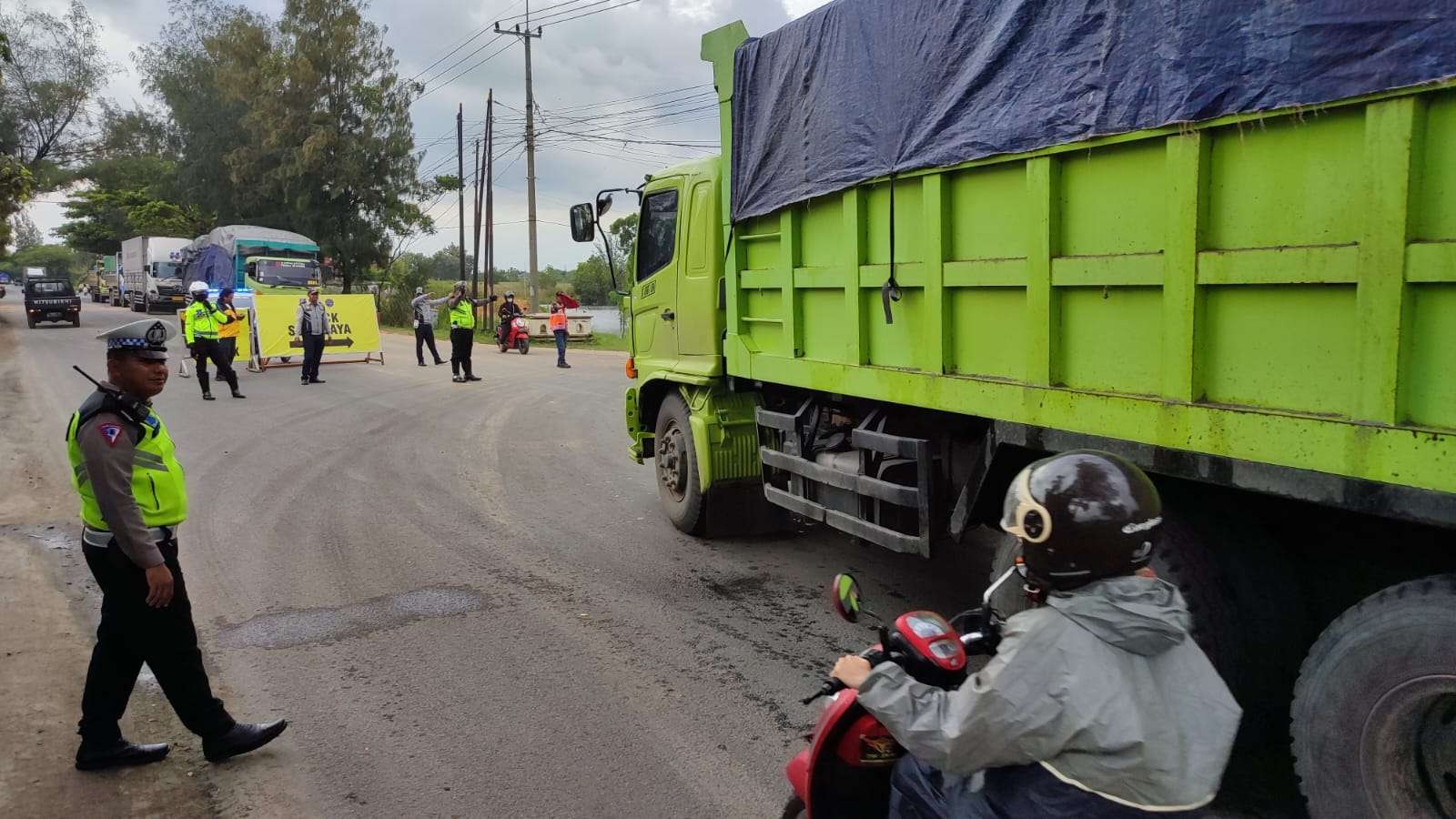 Petugas melakukan pengaturan arus lalu lintas terkait uji coba pengalihan arus lalu lintas kendaraan besar ke jalan Lingkar Selatan atau ring road Tuban, Jawa Timur. (Foto: Khoirul Huda/Ngopibareng.id)