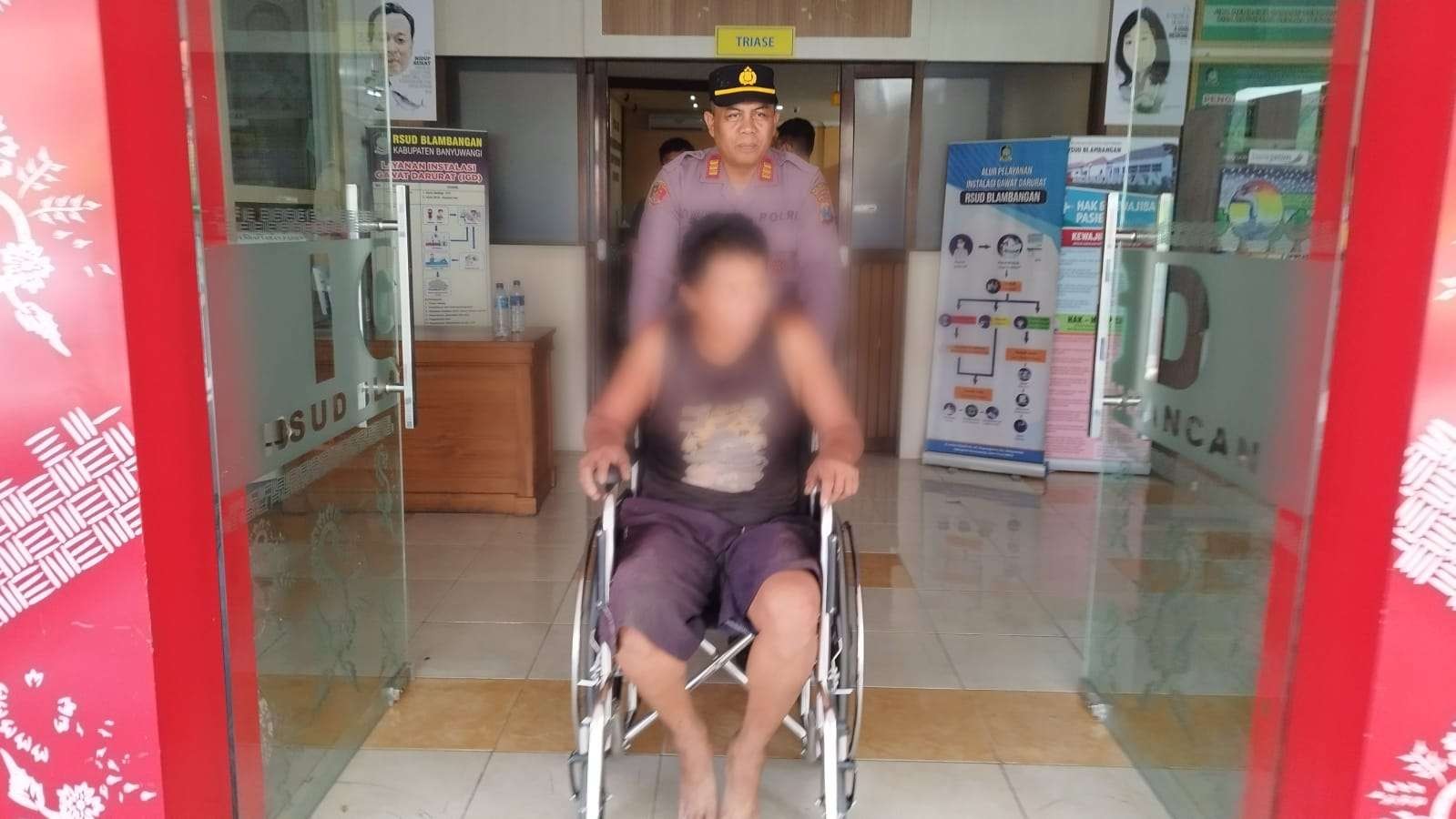 Kapolsek Kalipuro, AKP Hadi Waluyo mendorong kursi yang diduki pelaku usai menjalani pemeriksaan di RSUD Blambangan (foto: Muh Hujaini/Ngopibareng.id)