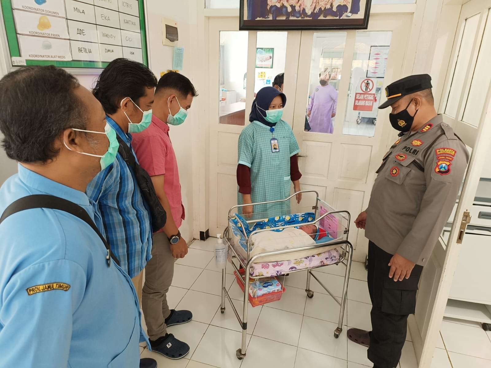 Kapolsek Banyuwangi AKP Kusmin mengecek kondisi bayi yang ditemukan di warung kopi. (Foto: Istimewa)