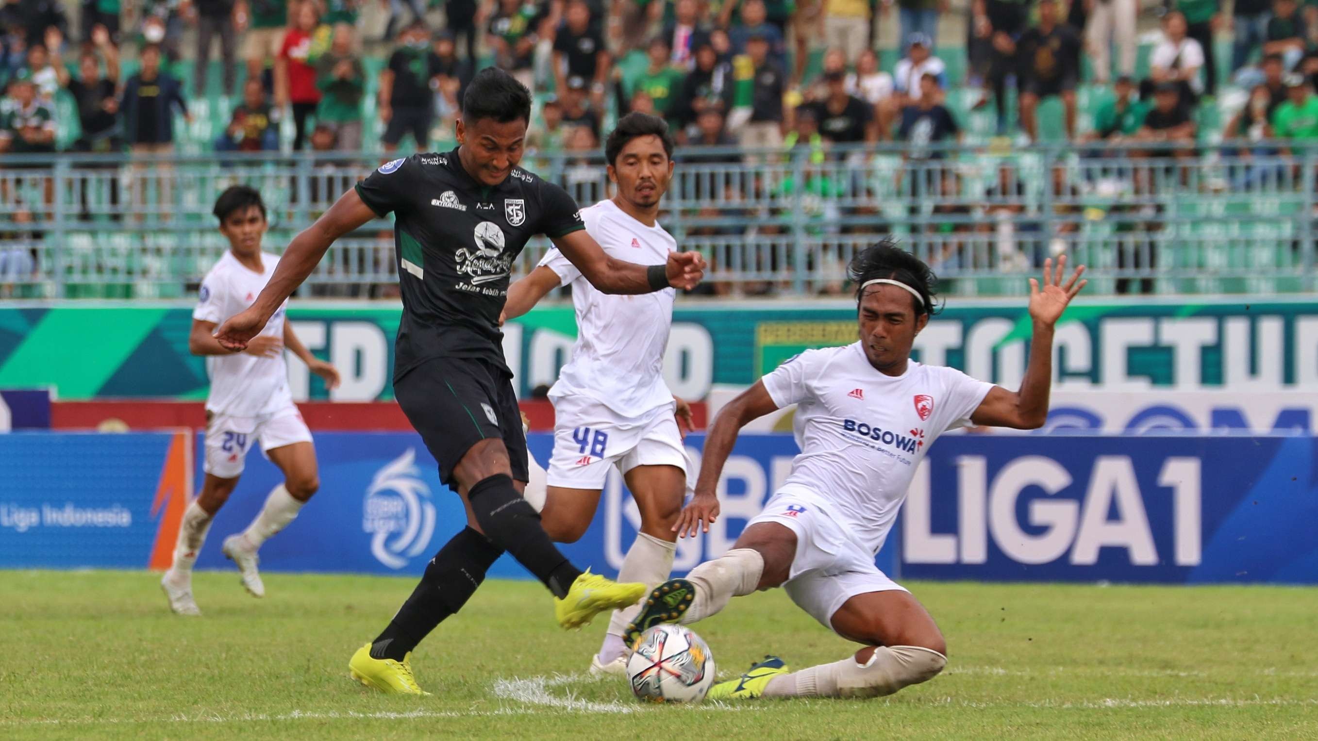 Pemain Persebaya, Januar Eka mencoba melakukan tembakan yang masih bisa di blok Pemain PSM Erwin Gutawa di Stadion Gelora Joko Samudro, Gresik, Jumat 25 Februari 2023. (Foto: Fariz Yarbo/Ngopibareng.id)