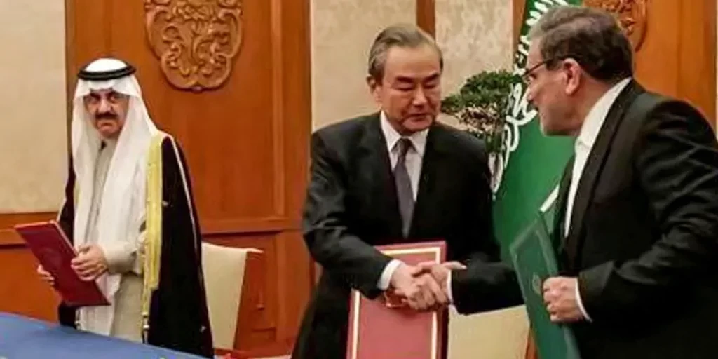 Ali Shamkhani, penasihat dekat pemimpin tertinggi Iran Ayatollah Ali Khameni (kanan), berjabat tangan dengan Wang Yi dari Partai Komunis China selama pertemuan dengan penasihat Keamanan Nasional Arab Saudi dan Menteri Negara Musaad bin Mohammed al-Aiban di Beijing, Jumat. (Foto: getty image)