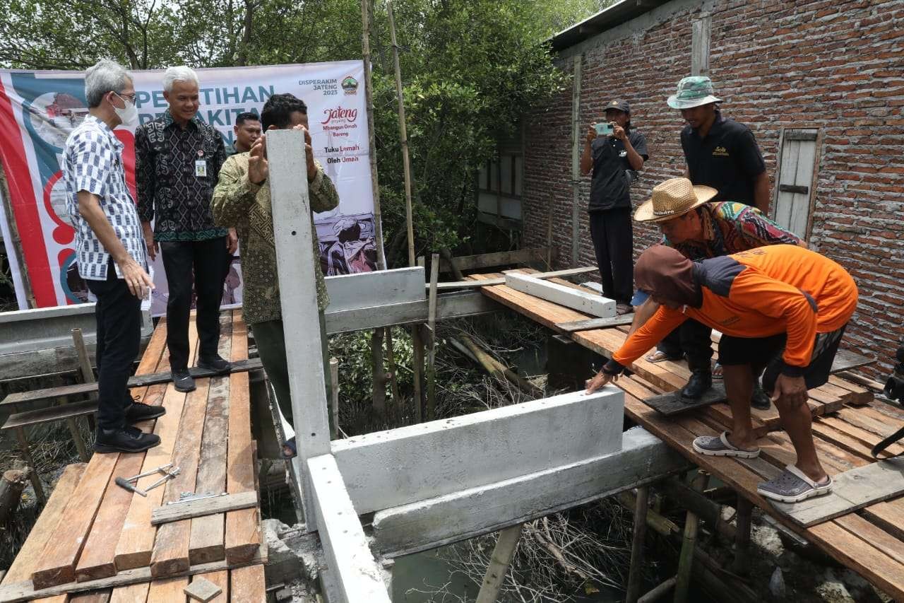 Gubernur Jawa Tengah Ganjar Pranowo tampak tengah meninjau program bantuan rumah sistem panel instan (Ruspin) model rumah panggung untuk korban bencana rob di Desa Bedono, Kecamatan, Sayung, Kabupaten Demak, Selasa 14Maret 2023. (Foto: istimewa)