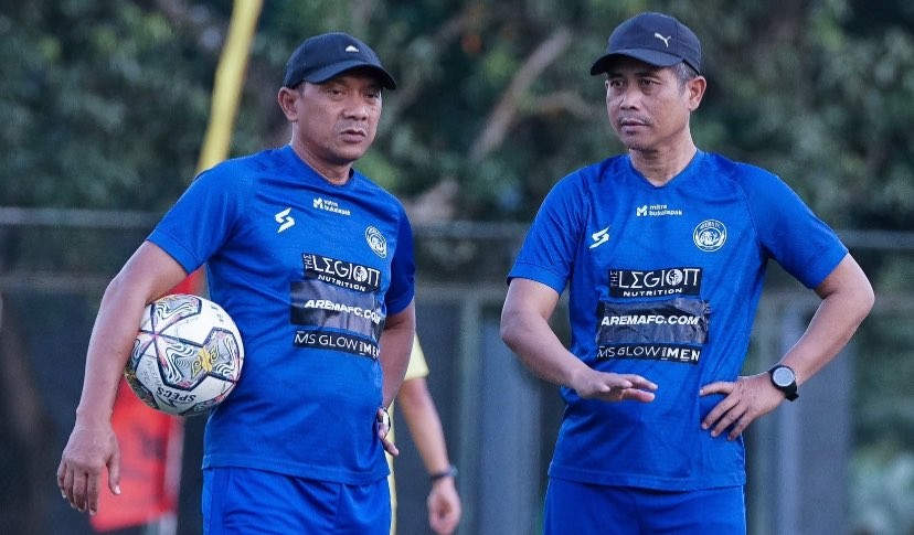 Assisten pelatih Arema FC, I Putu Gede (kiri) dan pelatih kepala Arema FC, Joko ‘Gethuk’ Susilo (kanan) memantau sesi latihan tim. (Foto: Twitter @AremafcOfficial)