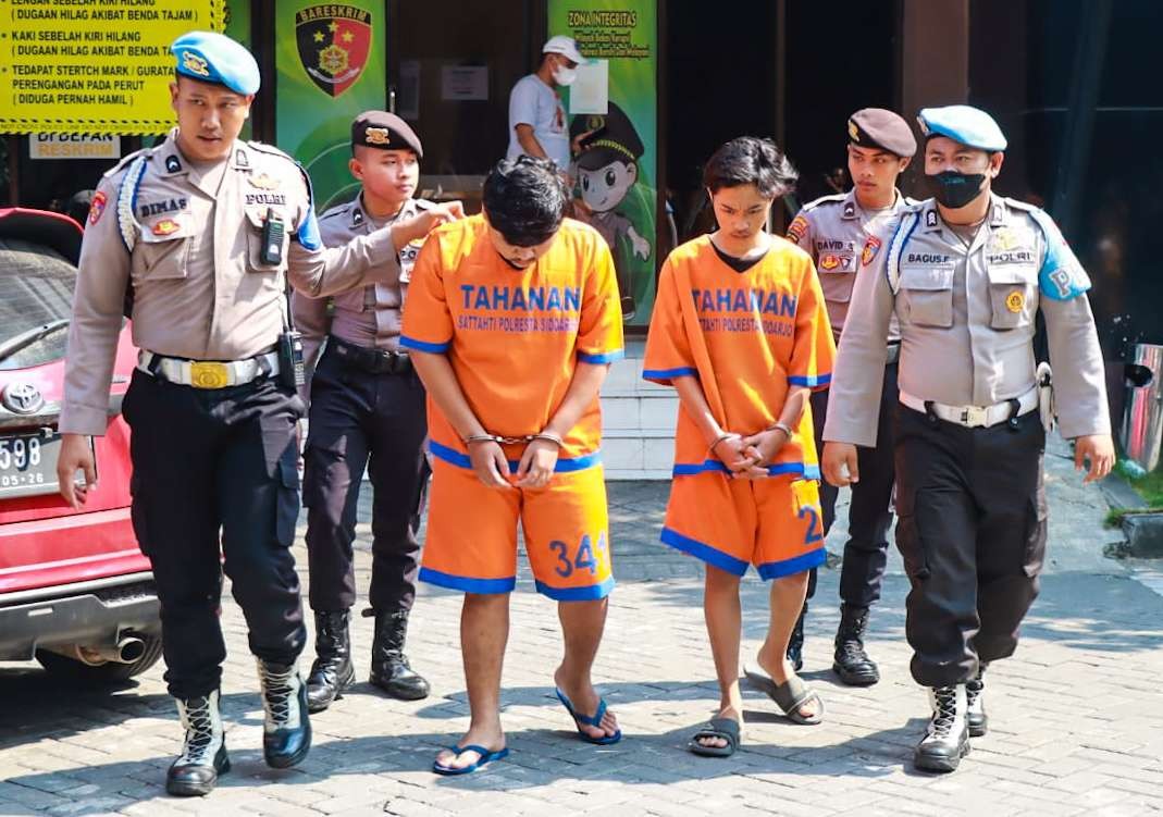 Dua tersangka pemilik senjata tajam berbentuk sabit berukuran besar (foto : Aini/Ngopibareng.id)