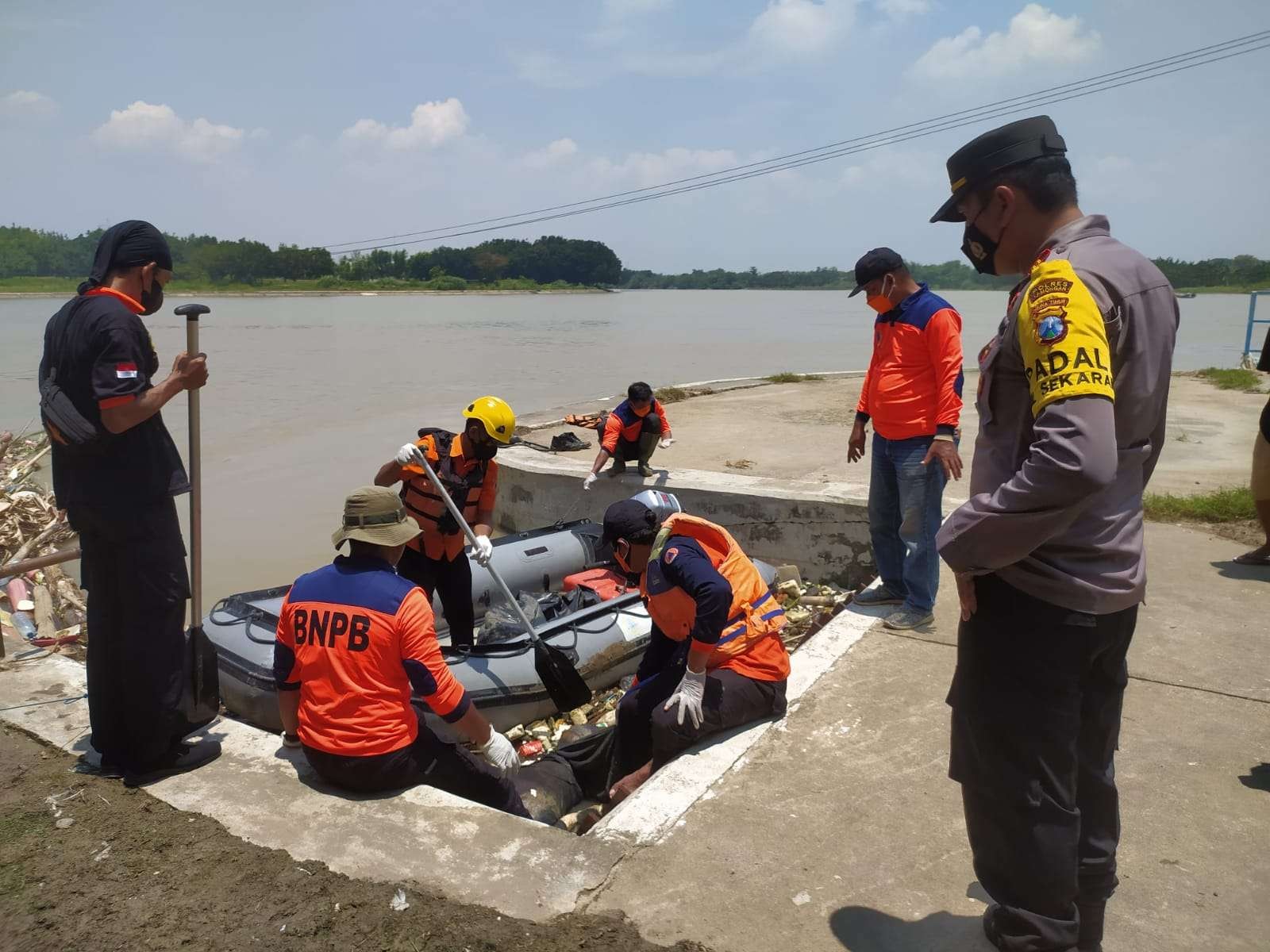 Tim SAR BPBD Lamongan bersama petugas anggota polsek dan koramil serta warga setempat mengevakuasi mayat korban. (Foto: Istimewa)