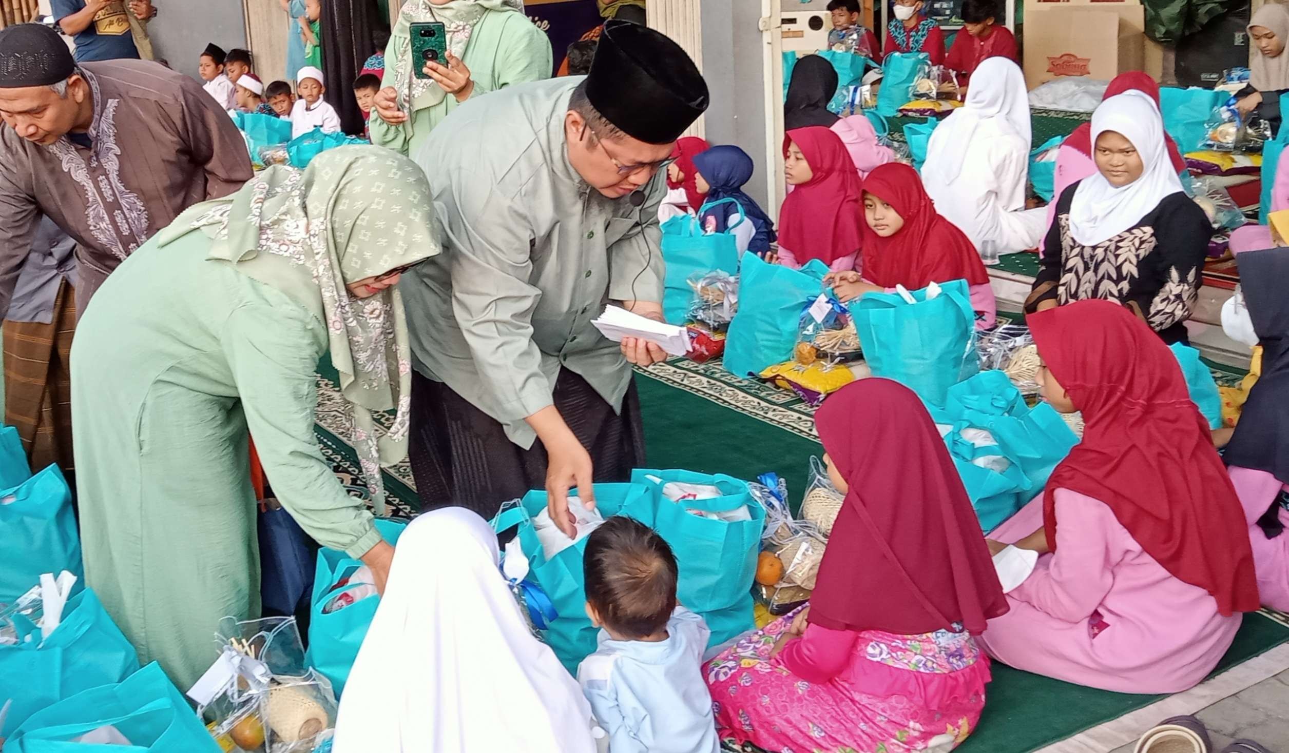 Ketua Yayasan Assyifa, Warahma Teguh Widada membagikan bingkisan Ramadan kepada anak yatim. (Foto: Asmanu Sudarso/Ngopibareng.id)