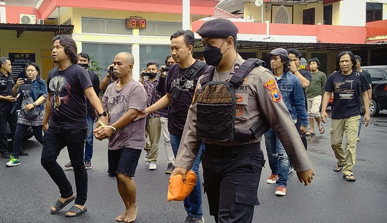 Tersangka dalam kondisi tangan diikat saat dibawa ke ruang konferensi pers (Foto: Rusdi/Ngopibareng.id)