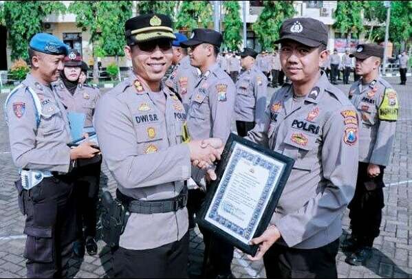 Kapolres Situbondo AKBP Dwi Sumrahadi menyerahkan penghargaan kepada 12 anggota polres berprestasi dalam menjalankan tugas pokok dan fungsinya.(foto:guido/ngopibareng.id)