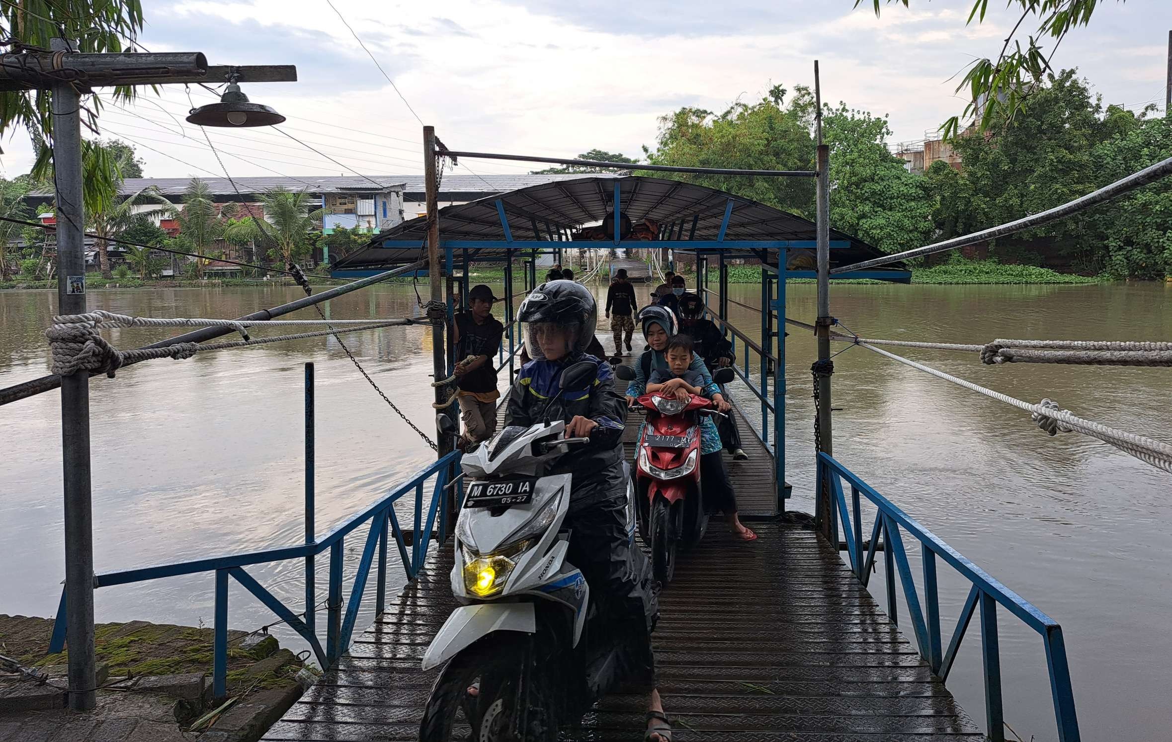 Warga Pagesangan yang masih memilih menggunakan perahu tambang untuk menyebrang. (Foto: Pita Sari/Ngopibareng.id)