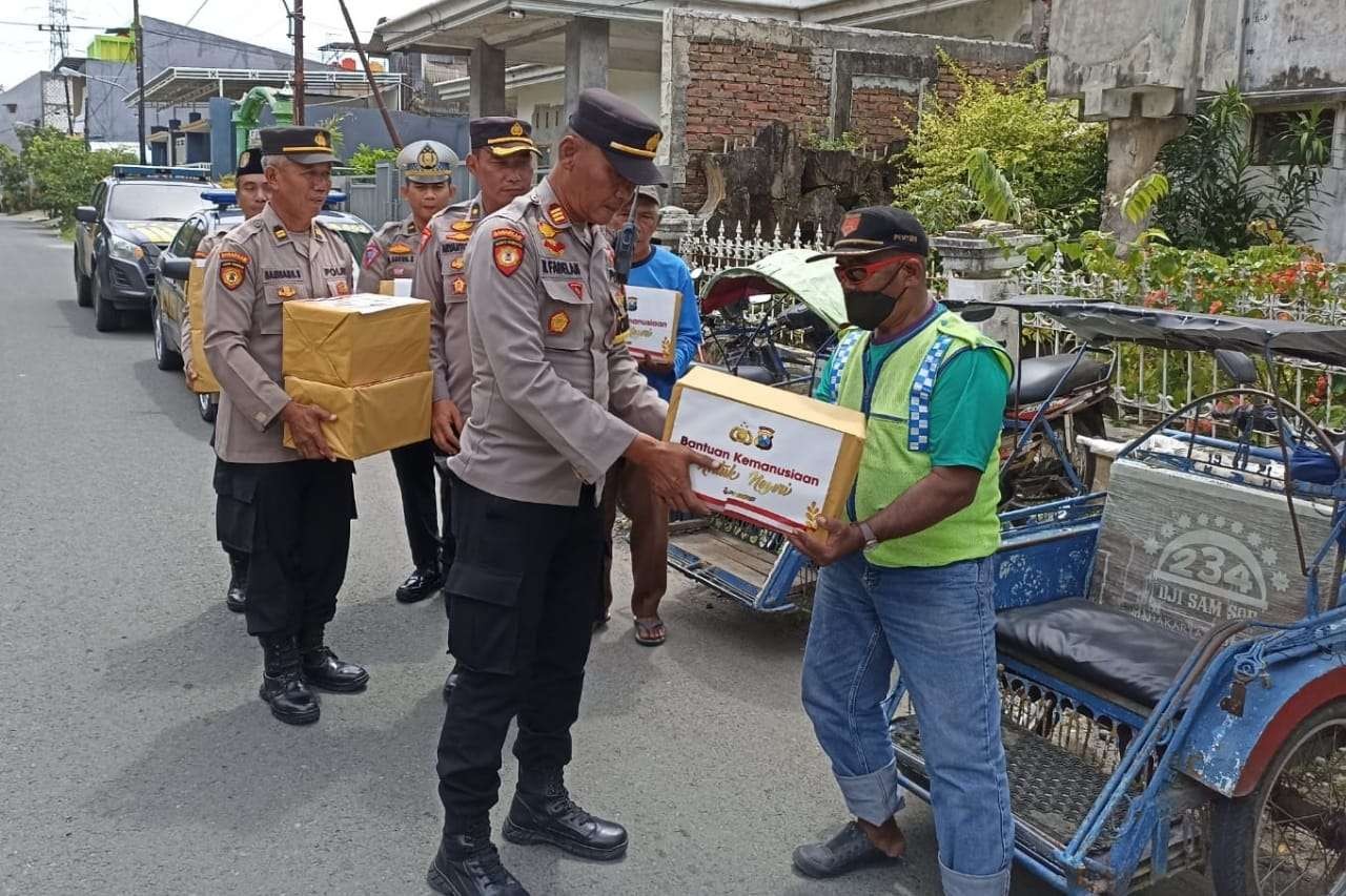 Anggota Polres Lamongan menyerahkan bantuan kepada tukang becak. (Foto: Imron Rosidi/Ngopibareng.id)