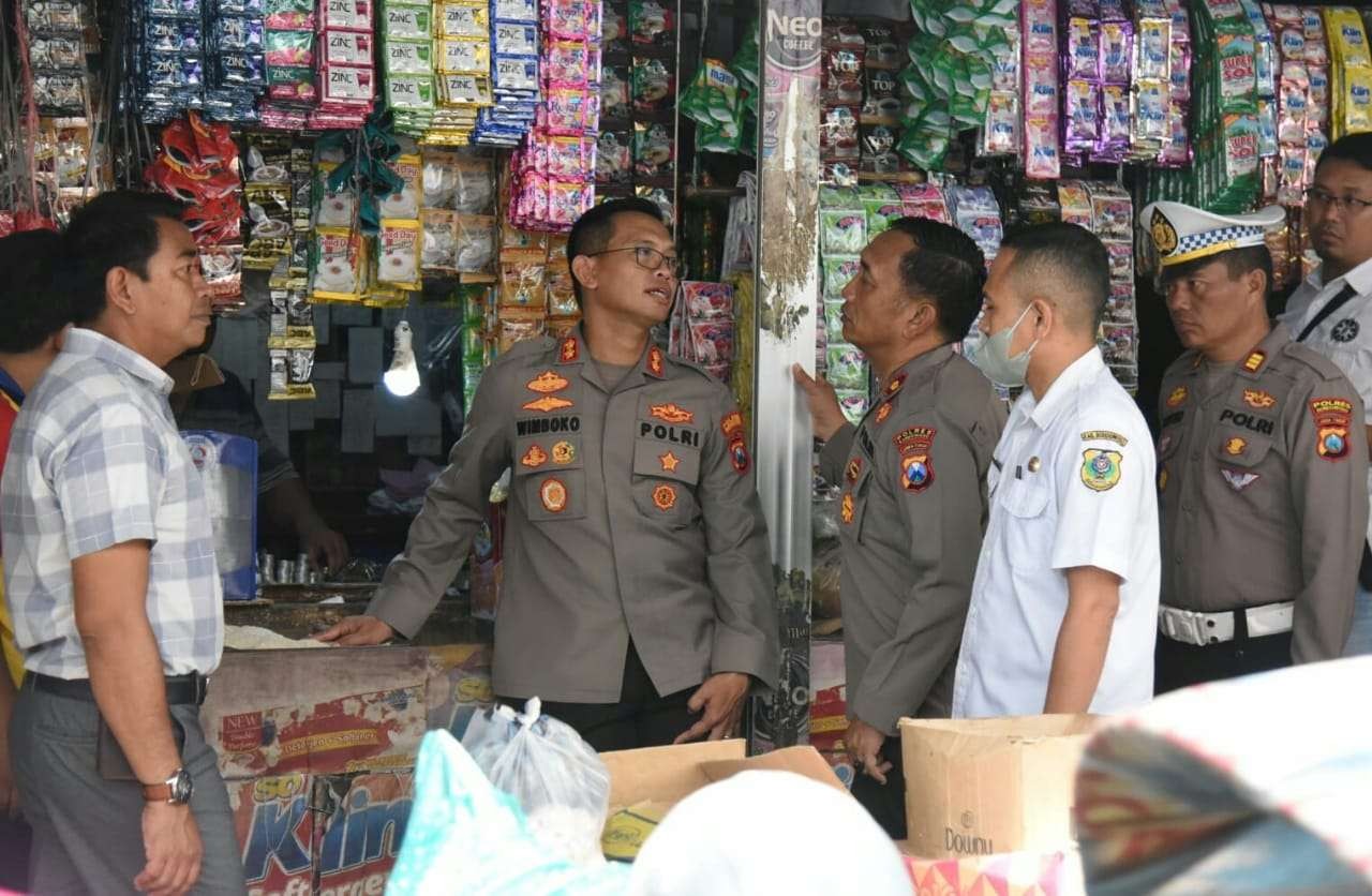 Kapolres Bondowoso AKBP Wimboko bersama anggotanya dan petugas Diskoperindag setempat memantau harga kebutuhan pokok selama Ramadan di Pasar Induk Bondowoso.(foto:guido/ngopibareng.id)