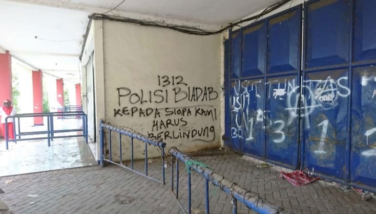 Grafiti bernada protes di gerbang masuk Stadion Kanjuruhan. (Foto: Ngopibareng.id)