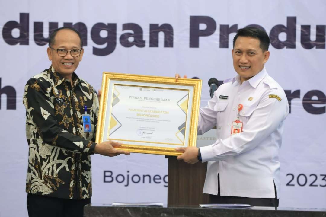 Kakanwil Jatim Imam Jauhari memberikan penghargaan Pemkab Sadar Kekayaan Intelektual di Wilayah Provinsi Jatim kepada Kepala Dinas Perindustrian dan Tenaga Kerja Bojonegoro Welly Fitrama. (Foto: Humas Kemenkumham Jatim)