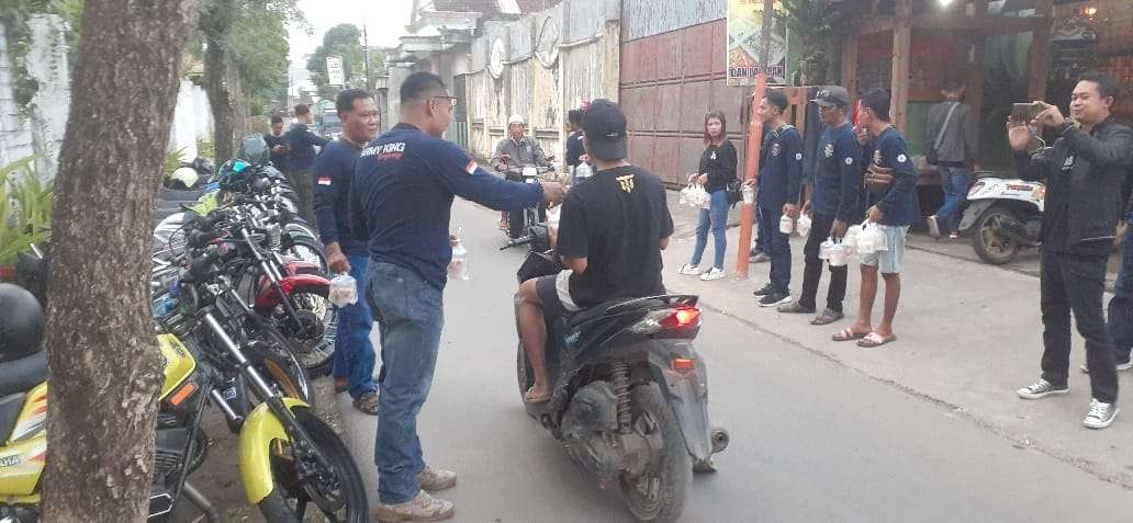 Anggota Konunitas Motor RX King membagikan takjil kepada pengguna jalan (foto: istimewa)