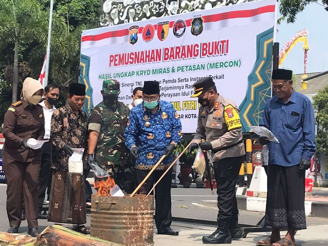 Kapolres Blitar Kota AKBP Argowiyono bersama Walikota Blitar Santoso, dan jajaran Forum Komunikasi Pemerintah Daerah Kota Blitar sedang memusnahkan barang bukti. (Foto: Choirul Anam/Ngopibareng.id)