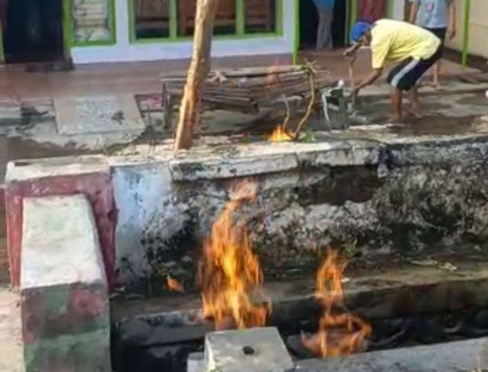 Warga Jalan Merapi, Kota Probolinggo  memadamkan jaringan gas bumi yang terbakar. (Foto: Ikhsan Mahmudi/Ngopibareng.id)