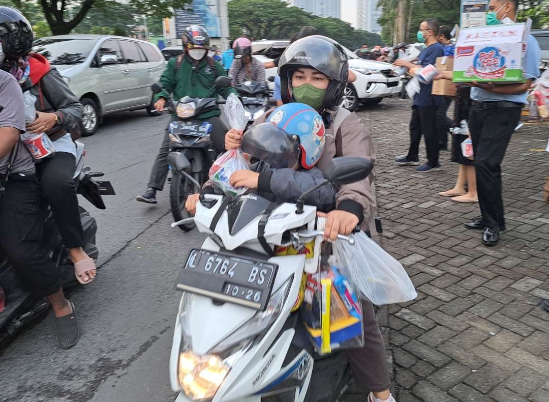 Pembagian takjil pada anak-anak yang berisi tips mudik saat membawa anak. (Foto: Pita Sari/Ngopibareng.id).