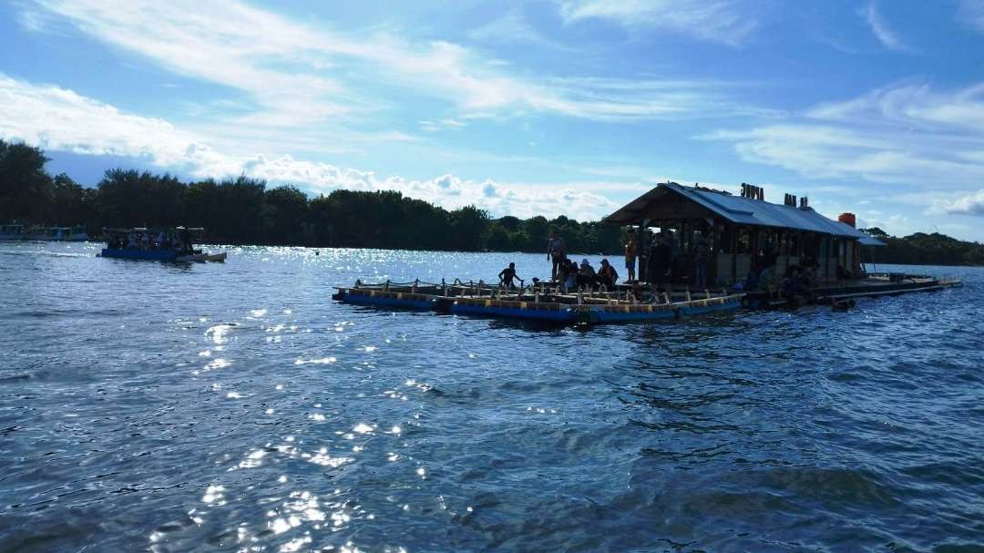 Wisatawan menghabiskan waktunya untuk snorkeling dan bermain dengan ikan di rumah apung yang ada di Bangsring Underwater. (Foto: Muh Hujaini/Ngopibareng.id)