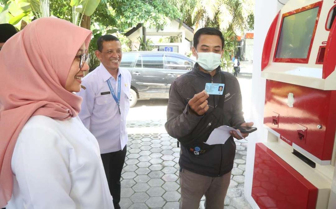 Bupati Ipuk melihat seorang warga yang sedang menggunakan layanan Adminduk. (Foto: Humas Pemkab Banyuwangi)