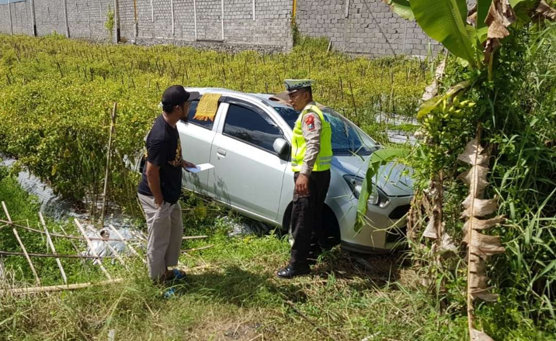 Petugas Kepolisian hendak mengevakuasi kendaraan yang terperosok ke sawah (foto:istimewa)