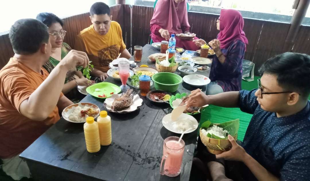 Menikmati menu desa di warung lesehan Pak No, Trawas, Mojokerto dengan sambal pencit membuat pengunjung penasaran. (Foto: Asmanu Sudharso/Ngopibareng.id)