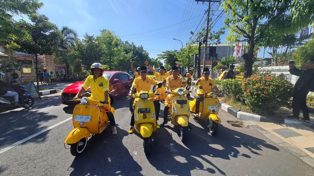 Bacaleg Golkar Lamongan mengendarai motor vespa saat mendaftar di KPU Lamongan (Fofo: Imron Rosidi/ngopibareng.id)