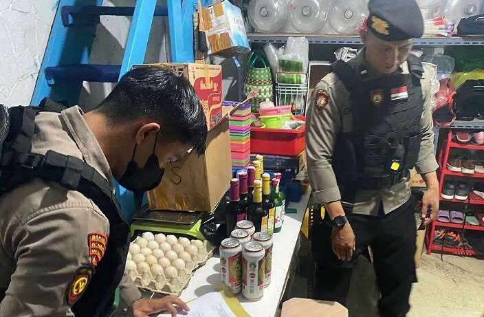 Anggota Satsamapta Polres Situbondo mengamankan puluhan botol miras hasil razia ke sejumlah toko minuman.(Foto: Humas Polres Situbondo)