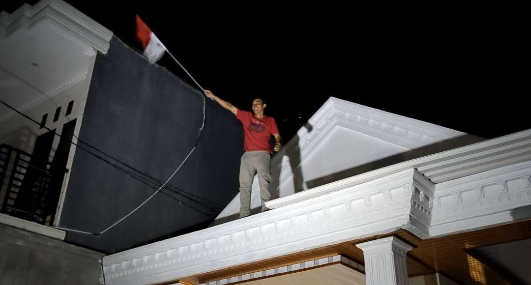 Ayah Kapten Timnas Indonesia Rizky Ridho, Sutoyo melakukan selebrasi di atas rumah menyambut kemenangan Indonesia di final SEA Games 2023 Kamboja. (Foto: Fariz Yarbo/Ngopibareng.id)