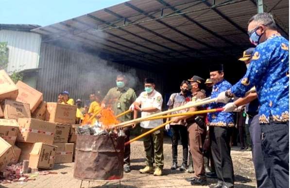 Ratusan ribu rokok ilegal dengan cukai palsu dibakar di TPA, setelah kasus hukum inkrah. (Foto: Guido Saphan/Ngopibareng.id).