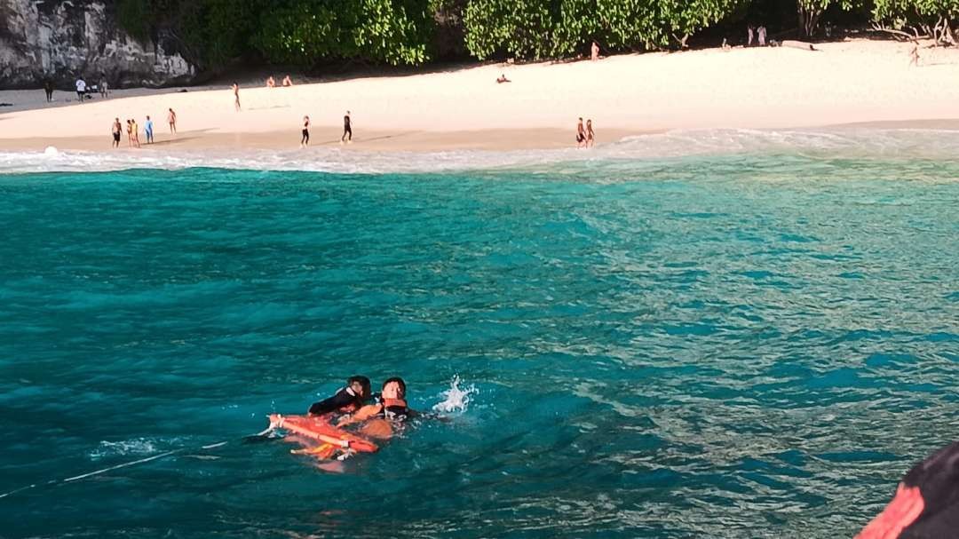 Petugas Basarnas mengevakuasi tursi Jerman mengalami dislokasi lengan saat berenang. (Foto: Basarnas Bali)