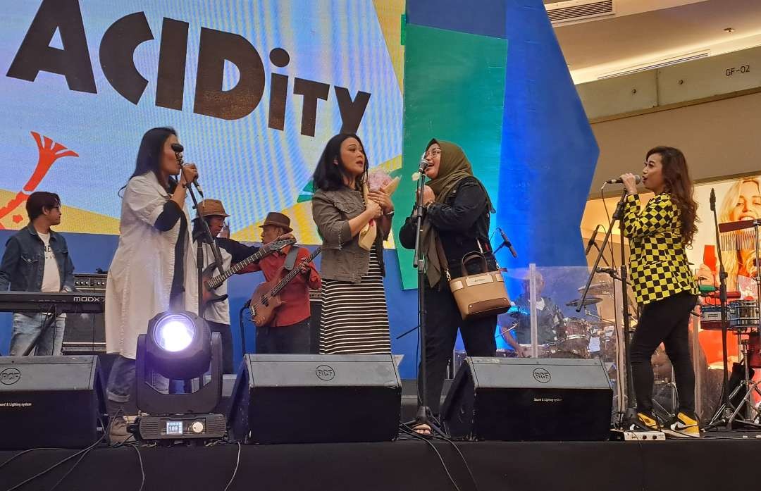 Salah satu penonton yang memberikan bunga saat ACIDity Band tampil di NgejazzReK. (Foto: Pita Sari/Ngopibareng.id)