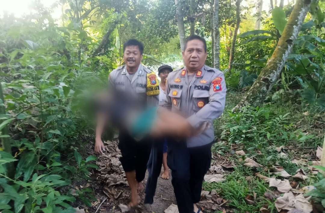 Kapolsek Glenmore AKP Satrio Wibowo mengevakuasi AP, bocah yang tenggelam saat berenang (foto:istimewa )