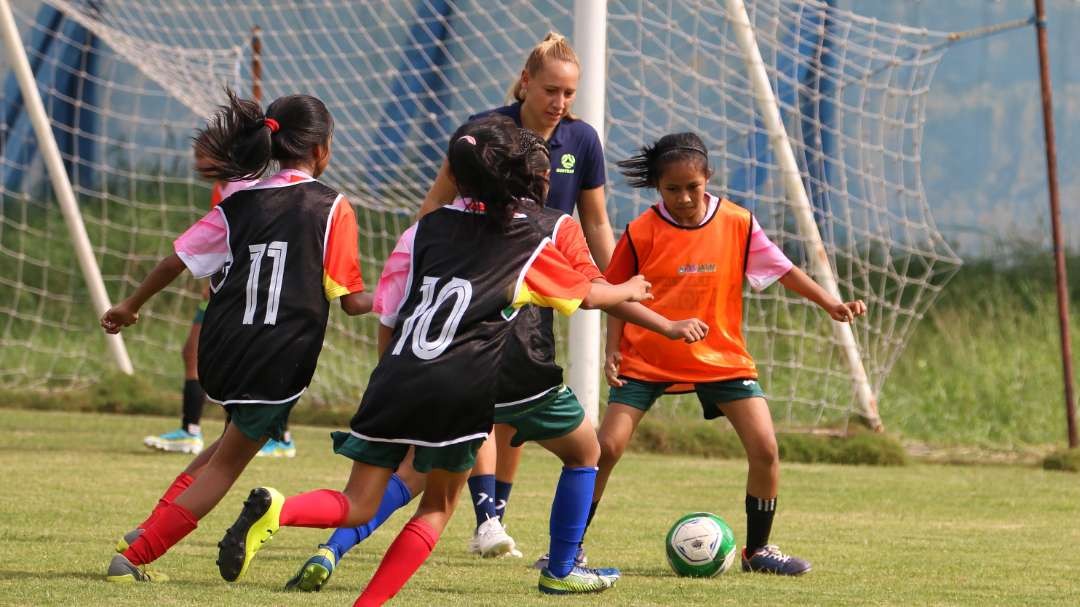 Pemain Timnas Australia, Gema Simon (tengah) saat bermain bola dengan anak-anak di Lapangan Unesa, Surabaya, Kamis 8 Juni 2023. (Foto: Fariz Yarbo/Ngopibareng.id)