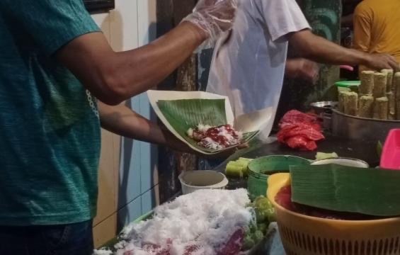 Potongan kue Puthu Lanang saat ditaburi cairan gula merah (Foto: Lalu Theo/Ngopibareng.id)