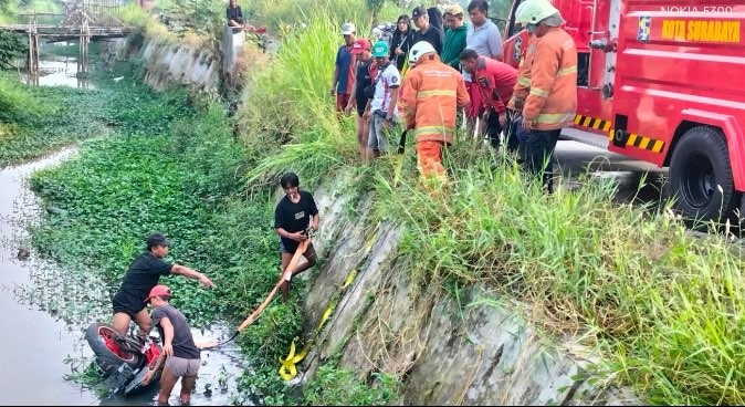 Evakuasi pengendara motor tercebut di parit Kecamatan Pakal (Foto: dok. BPBD Surabaya)