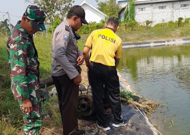 Anggota Polsek Glagah dan Koramil setempat saat melakukan olah TKP di kolam ditemukannya korban tewas (Foto: Istimewa)