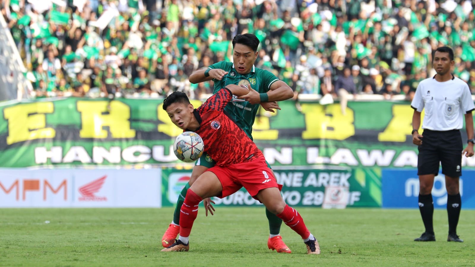 Pemain Persebaya, Song Ui-Young (hijau) berebut bola dengan Pemain Persija, Syahrian Abimanyu di Stadion Gelora Bung Tomo, Surabaya, Minggu 18 Juni 2023. (Foto: Fariz Yarbo/Ngopibareng.id)