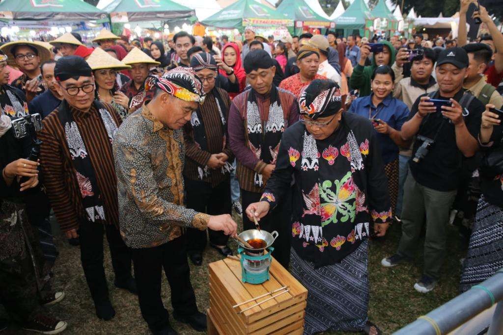 Menko PMK Muhadjir Effendy bersama Walikota Blitar Santoso melakukan kegiatan mengisi beras pucuk ketupat, dalam kegiatan pembukaan Bazar Blitar Djadoel 2023, pada Sabtu 17 Juni 2023. (Foto: istimewa)