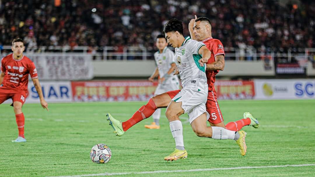 Pemain Persebaya, M Iqbal (putih) saat mencoba melewati penjagaan pemain Persis Solo, Jamierson di Stadion Manahan, Solo, Sabtu 24 Juni 2023 malam. (Foto: Persebaya)