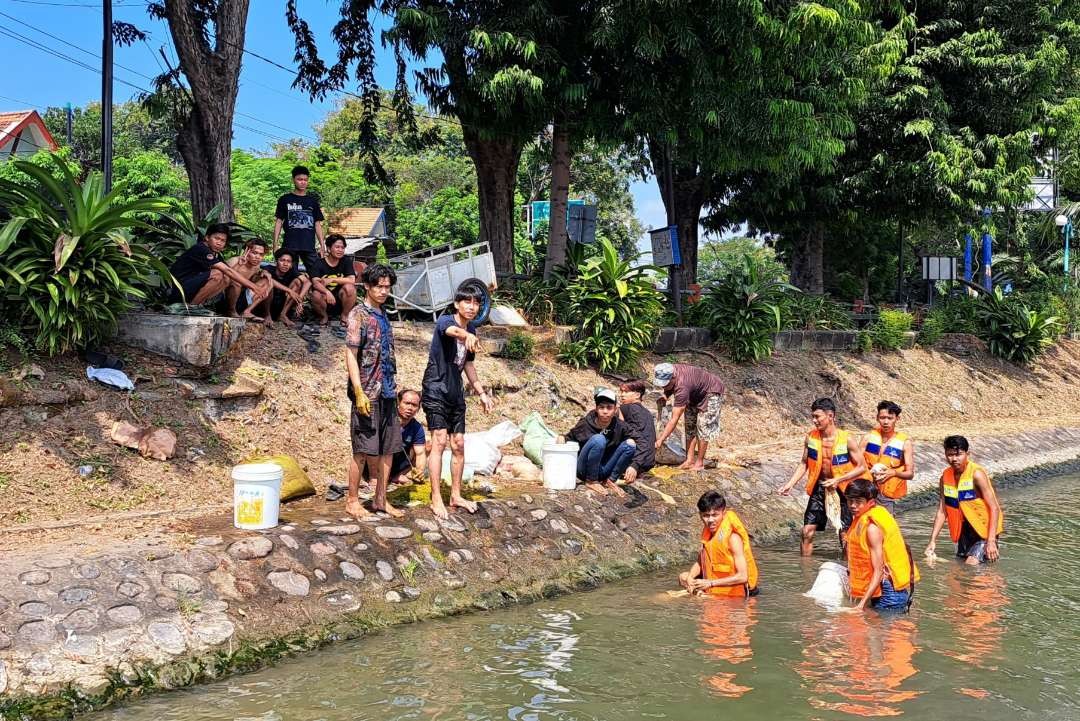 Warga Surabaya yang secara berkelompok mencuci rumen di bibir sungai Kalimas, siang ini. (Foto: Pita Sari/Ngopibareng.id)