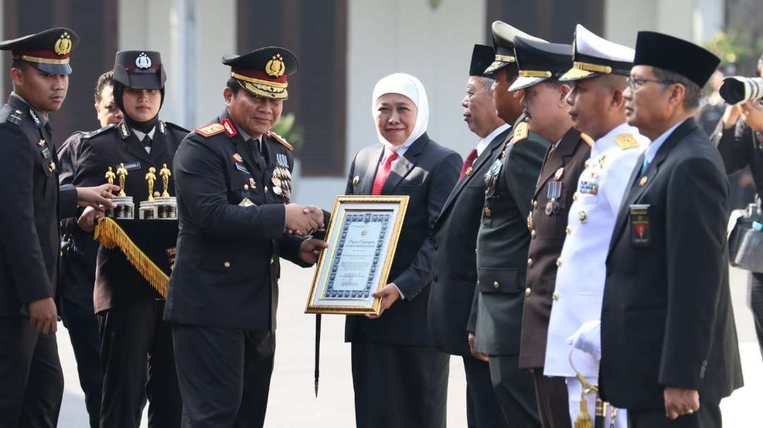 Kapolda Jatim Irjen Pol Toni Harmanto memberikan penghargaan kepada Gubernur Jatim Khofifah Indar Parawansa dalam peringatan Hari Bhayangkara ke-77 di Gedung Negara Grahadi, Surabaya, Sabtu 1 Juli 2023. (Foto: Fariz Yarbo/Ngopibareng.id)