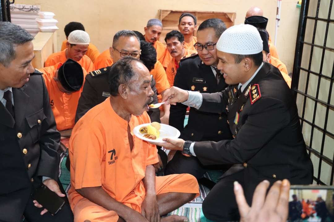 Kapolres Sumenep AKBP Edo Satya Kentriko, S.H., S.I.K., M.H merayakan HUT ke-77 Bhayangkara dengan menyuapi makanan kepada seorang tahanan lanjut usia di Markas Polres Sumenep, Sabtu 1 Juli 2023. (Foto: Istimewa)