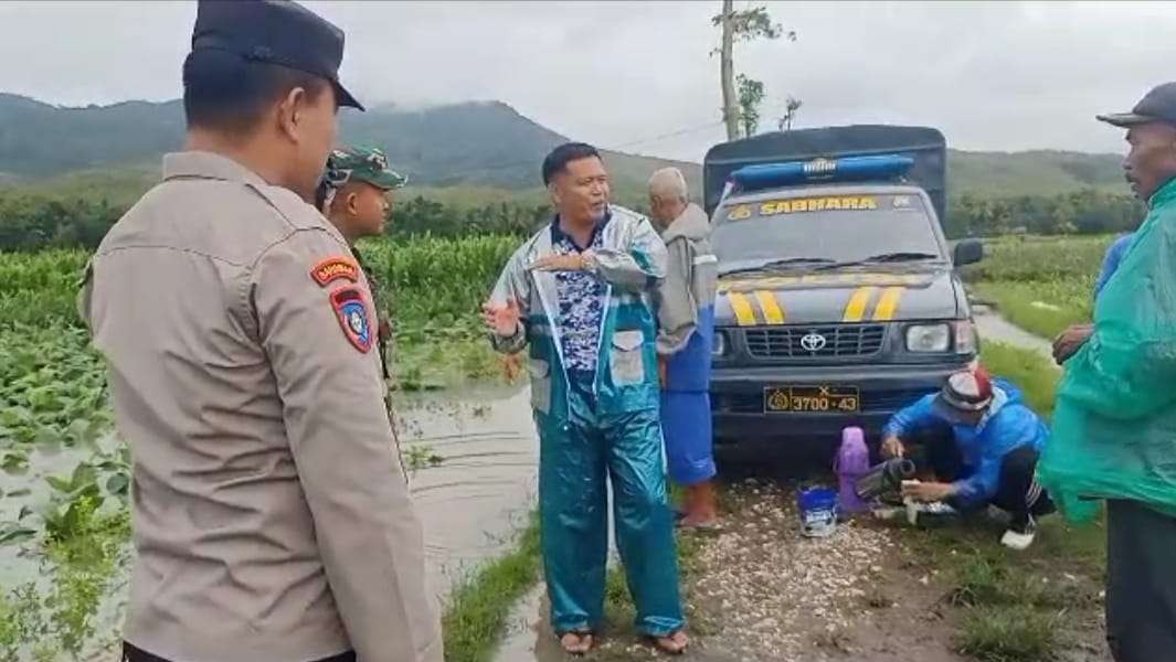 Ketua HKTI Jember, Soleh bersama Babinsa dan Babinkantibmas memantau lahan terendam air sambil membagi-bagikan minuman kopi. (Foto: Dok HKTI Jember)