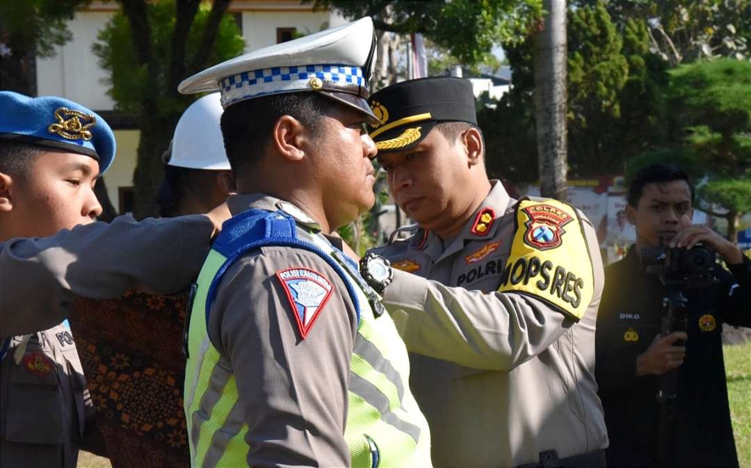 Kapolres Bondowoso, AKBP Bimo Ariyanto memasang pita Operasi Patuh Semeru 2023 kepada anggota Polres, TNI, Dishub, dan Satpol PP di Mapolres Bondowoso, Senin 10 Juli 2023. (Foto: Guido Saphan/Ngopibareng.id)