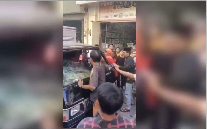 Tangkapan layar warga yang menyerang dengan beringas pengemudi mobil yang diduga anggap mengganggu warga yang sedang berduka cita. (Foto: Tangkapan Layar)