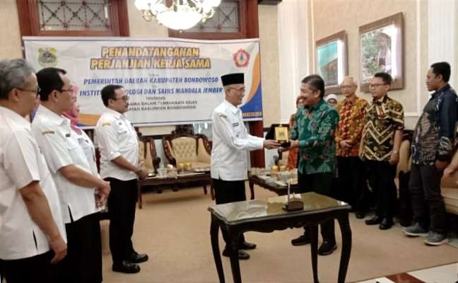 Bupati Bondowoso Salwa Arifin dan Rektor ITS Mandala Jember, Suwigyo Widagdo bertukar cindera mata usai kesepakatan bersama di Pendapa Bupati Raden Bagus Assra Bondowoso.(Foto:Guido/Ngopibareng.id)