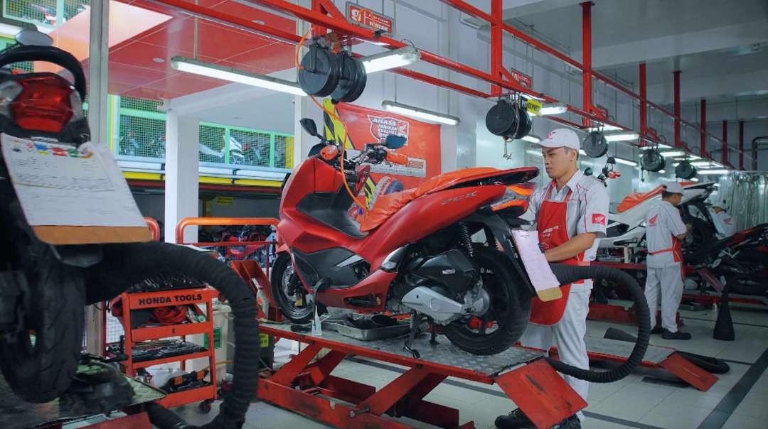 Mekanik bengkel bengkel AHASS sedang melakukan servis motor. (Foto: MPM Honda Jatim)