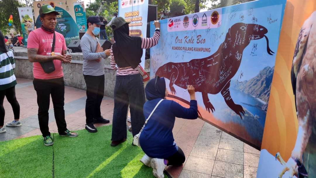 Warga membubuhkan tanda tangan di papan dukungan yang disediakan PT Smelting di Taman Bungkul, Surabaya, Minggu 16 Juli 2023. (Foto: Fariz Yarbo/Ngopibareng.id)