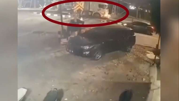 CCTV memperlihatkan truk melintas rel saat sirine palang kereta api bunyi. Seketika truk mogok di atas rel. (Foto: Tangkapan layar video)