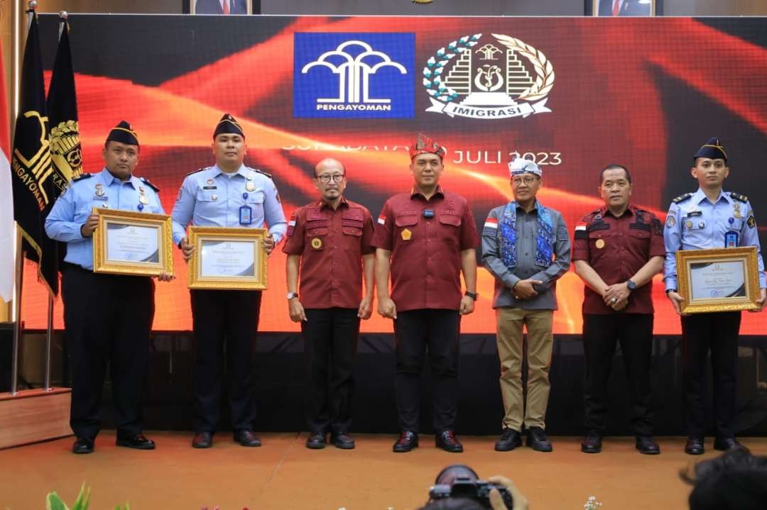 Direktur Jenderal Imigrasi, Silmy Karim dan Kakanwil Kemenkumham Jatim Imam Jauhari, saat memberikan penghargaan terhadap tiga petugas Kantor Imigrasi Kelas II Non TPI Ponorogo, yakni Hendro Tri Kusumo Atmojo (35), Arief Rachmaddan (30) dan Iqbal Aly Noor Said (26) di Aula Kantor Imigrasi Kelas I Khusus TPI Surabaya, Kamis 20 Juli 2023. (Foto Dok. Humas Kemenkumham Jatim)